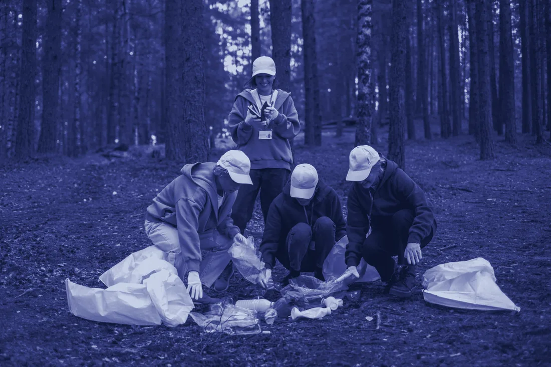 A community group clearing litter together in a wood